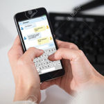 Person Sending Messages On Cell Phone